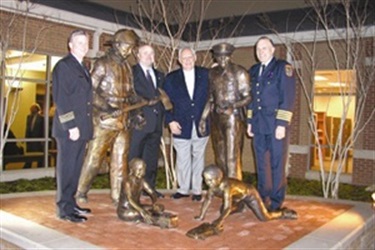 Charles V. England Public Safety Training Complex - Dedicated to the public safety personnel who protect the citizens and businesses of Grand Prairie, the sculpture features a life-size police officer and firefighter, as well as two small children playing with a fire truck and police car. The sculpture alludes to the daily heroism of Grand Prairie police officers and firefighters, who are the protectors of our future and suggests professional admiration and inspiration.